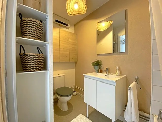 Salle de bain chaleureuse et pratique, avec rangements et décoration naturelle. Idéale pour un studio étudiant à Aix-en-Provence.